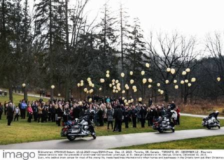 Dec. 10, 2015 - Toronto, ON, Canada - TORONTO, ON - DECEMBER 10 - Mourners release balloons near the gravesite of seven-year-old son Evan Leversage, at St. George Cemetery in St. George, Ontario, December 10, 2015. Evan, who battled brain cancer for most of his young life, made headlines internationally when homes and businesses in the Ontario town put their Christmas decorations up in October, after doctors told his family he was unlikely to live to Christmas and they should celebrate early. Toronto Canada - ZUMAt14_