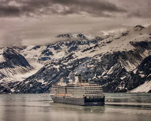 July 3, 2012 - Glacier Bay, Alaska, US - Holland America Lines ms Westerdam cruising past the awe-inspiring, snow topped peaks of the Fairweather Mountain Range in Glacier Bay, whose landscape can dwarf the largest ships that enter its waters. Glacier Bay covers 3.3 million acres (1.3 million hectares) of rugged mountains, dynamic glaciers, temperate rainforest, wild coastlines, deep sheltered fjords and wildlife. A highlight of the Alaskan Inside Passage and part of a 25-million acre (10.1 million hectares) World Heritage Site, it is the largest UNESCO protected biosphere in the world. Almost half a million tourists visit each year, mostly cruise ship passengers. - ZUMAd84