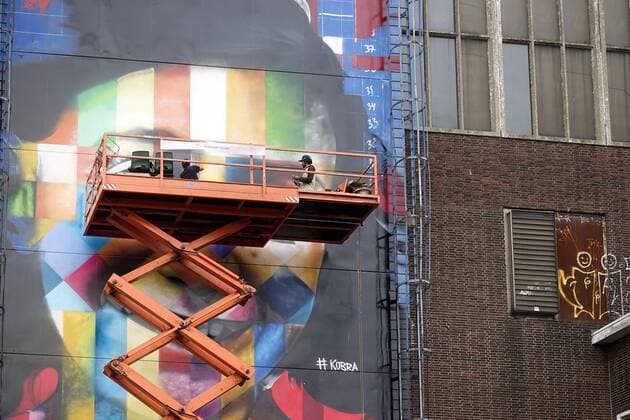 The Netherlands, Amsterdam. The famous Brazilian street artist Eduardo Kobra realizes this week a monumental portrait of Anne Frank. 26 september 2016, Photo: Katrien Mulder Hollandse Hoogte Nederland, Amsterdam, Amsterdam Noord, NDSM Terrein, wereldberoende Braziliaanse streetartist Eduardo Kobra realiseert deze week een monumentaal portret van Anne Frank op de zuidelijke buitenmuur van de loods op de hoek van de MS van Riemsdijkweg, en de Tt Neveritaweg, famous Brazilian street artist Eduardo Kobra realizes this week a monumental portrait of Anne Frank, de man rechts in de hoogwerker is Eduardo Kobra, the man at the right side of the platform is Eduardo Kobra, 26 september 2016, foto: Katrien Mulder 59396756