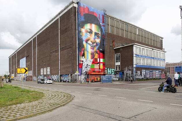 The Netherlands, Amsterdam. The famous Brazilian street artist Eduardo Kobra realizes this week a monumental portrait of Anne Frank. 26 september 2016, Photo: Katrien Mulder Hollandse Hoogte Nederland, Amsterdam, Amsterdam Noord, NDSM Terrein, wereldberoende Braziliaanse streetartist Eduardo Kobra realiseert deze week een monumentaal portret van Anne Frank op de zuidelijke buitenmuur van de loods op de hoek van de MS van Riemsdijkweg, en de Tt Neveritaweg, famous Brazilian street artist Eduardo Kobra realizes this week a monumental portrait of Anne Frank, 26 september 2016, foto: Katrien Mulder 59396747