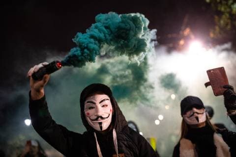 November 5, 2018 - London, London, UK - London, UK. A demonstrator lights a flare as he takes part in the Million Mask March, an anti-capitalist protest organised by Anonymous UK. The march takes place on bonfire night, the anniversary of Guy Fawkes plot to blow up the Houses of Parliament with gunpowder. London UK - ZUMAl94_ 20181105_zaf_l94_072 Copyright: xTomxNicholsonx