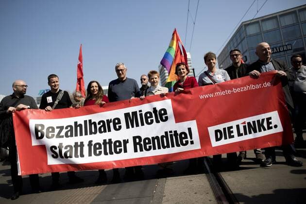 Volksentscheid Enteignung Berlin DEU, Deutschland, Germany, Berlin, 06.04.2019 Demonstranten der Partei Die Linke, Linkspartei, mit Transparent Mietenwahnsinn auf der Demonstration von Mieterorganisationen und politischen Initiativen gegen hohe steigende Mieten, teure Modernisierungen, Gentrifizierung, Verdraengung und Zwangsraeumungen unter dem Motto Widerstand Gemeinsam gegen Verdraengung und Mieterwahnsinn, Mieten Wahnsinn stoppen Mietenwahnsinn in Berlin. Ueber 35.000 Menschen protestieren auf einer Grossdemonstration von 240 Mieterinitiativen. Protest gehen den Immobilienkonzern Deutsche Wohnen, welche hier Wohnungen erwerben wollte. Demonstrators of the left wing party Die Linke, Linkspartei, with sign during a demonstration ot tenants rights organization representatives and activists demonstrate against rent increases and gentri