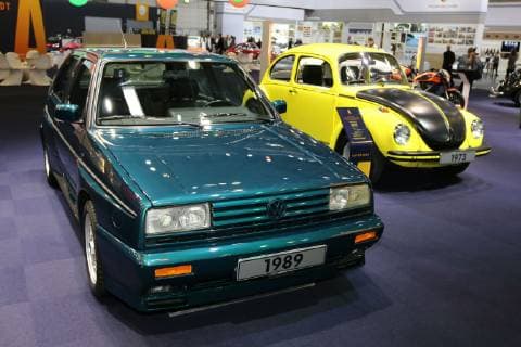 VW Rallye Golf (Baujahr 1989, Golf II) und VW 1303 S Gelb-Schwarzer Renner (Baujahr 1973, Käfer, rechts), Sonderausstellung getunt, veredelt, individualisiert auf dem Stand der Autostadt (VW Volkswagen), 31. Techno Classica Essen (10. - 14.04.2019). Messe Essen, Gruga, Grugahalle, Siha, Oldtimer klassische Autos Autoausstellung, Oldtimermesse, Essen (D).