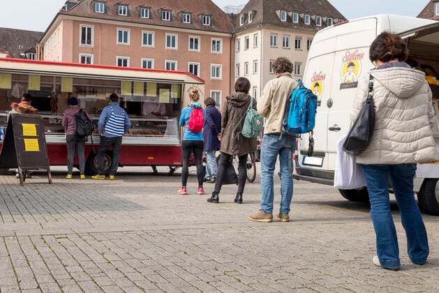 Wuerzburg, City, 20.03.2020, Coronavirus: Einkaufen in Zeiten Coronas Bild: Blick in die Würzburger Innenstadt am Freitagmittag Keine 12 Stunden später tritt in Bayern eine landesweite Ausgangsbeschränkung in Kraft. Damit soll die weitere Ausbreitung des Coronavirus bekämpft werden. Zahlreiche Menschen stehen in ausreichendem Abstand Schlange an einem Verkaufsstand. Coronavirus, COVID-19, Deutschland, Franken, Katastrophenfall, Konsum, Krankheiten, Mainfranken Copyright: HMBxMediax xPattyxVarasano