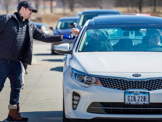 March 20, 2020, Des Moines, Iowa, U.S: ANDREW TOMES, the brand manger at the Foundry, a distillery in Des Moines, hands out hand sanitizer to waiting motorists. The distillery suspended its distilling operations to make hand sanitizer this week. They distributed it free to people who came to their building. On Friday thousands of people came to get some. There line was more than one mile long. On Friday morning, 20 March, Iowa reported 45 confirmed cases of the Coronavirus. Restaurants, bars, movie theaters, places that draw crowds are closed for at least 30 days. There are no shelter in place orders in effect anywhere in Iowa but people are being encouraged to practice social distancing and many businesses are requiring or encouraging employees to telecommute. Des Moines U.S. - ZUMAk94_ 20200320_zaf_k94_022 Copyright: xJackxKurtzx