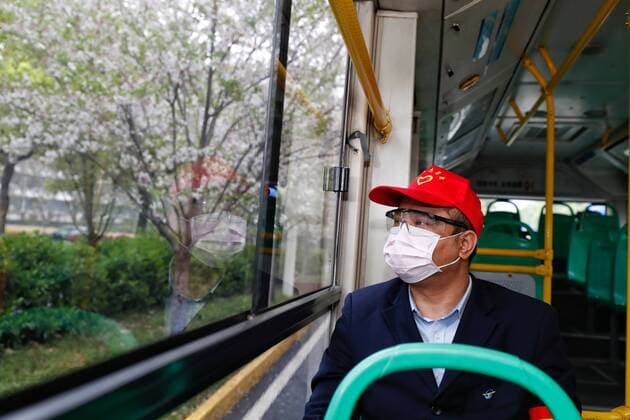 (200325) -- WUHAN, March 25, 2020 -- A staff looks out of the window on a bus in Wuhan, central China s Hubei Province, March 25, 2020. Wuhan, the once hardest-hit city in central China s Hubei Province during the COVID-19 outbreak, resumed a total of 117 bus routes starting Wednesday, around 30 percent of the city s total bus transport capacity, the municipal transport bureau said. According to a spokesperson of the bureau, passengers must wear masks, register with their names and scan a QR code, and take a temperature check before taking buses and subways. ) CHINA-HUBEI-WUHAN-COVID-19-BUS ROUTES-RESUMPTION (CN) ShenxBohan