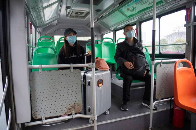 (200325) -- WUHAN, March 25, 2020 -- People take a bus in Wuhan, central China s Hubei Province, March 25, 2020. Wuhan, the once hardest-hit city in central China s Hubei Province during the COVID-19 outbreak, resumed a total of 117 bus routes starting Wednesday, around 30 percent of the city s total bus transport capacity, the municipal transport bureau said. According to a spokesperson of the bureau, passengers must wear masks, register with their names and scan a QR code, and take a temperature check before taking buses and subways. ) CHINA-HUBEI-WUHAN-COVID-19-BUS ROUTES-RESUMPTION (CN) CaixYang