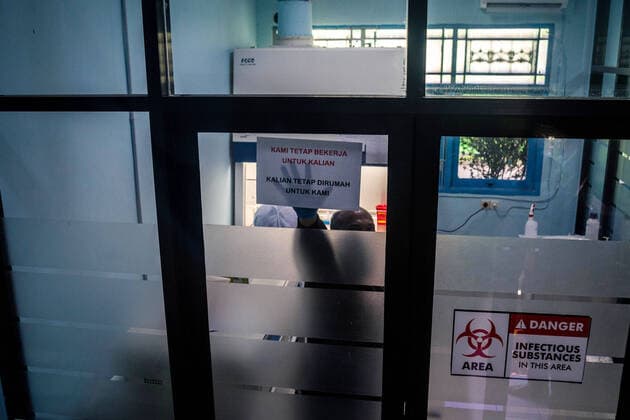 March 25, 2020, Makassar, South Sulawesi, Indonesia: Medical Officers at the Makassar Health Laboratory Center (BBLK), who are working in the laboratory testing a number of blood samples to determine whether Covid-19 is infected or not, show the writing on the paper telling people to stay at home, let them do the work. Since Tuesday, BBLM has examined blood samples from various regions in Sulawesi to conduct Covid-19 testing. More than 100 blood samples have been tested in this laboratory in Makassar City, South Sulawesi Province, Indonesia. Makassar Indonesia - ZUMAb223 20200325_zip_b223_011 Copyright: xHerwinxBaharx