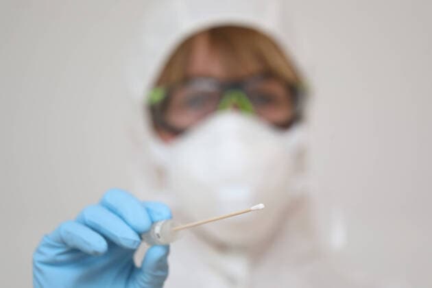28.03.2020, Berlin, GER - Gestellte Szene: Aerztin haelt ein Wattestaebchen eines Coronavirus-Tests in der Hand. (MR=yes, 40-50 Jahre, Aerztin, Alltag, Atemmaske, Berlin, Corona-Schnelltest, Corona-Test, Coronaepidemie, Coronainfektion, Coronapandemie, Coronavirus, Coronavirus-Schnelltest, Coronavirus-Test, Covid 19, Covid-19, deutsch, Deutschland, Europa, europaeisch, Frau, Freisteller, gestellte Szene, Infektion, Infektionsschutz, innen, Innenaufnahme, Kaukasierin, kaukasisch, Mensch, Mundschutz, Person, Probeentnahme, QF, Querformat, schemenhaft, Schutzbrille, Schutzkleidung, Studio, Studioaufnahme, testen, Wattestaebchen, Westeuropa, Wirtschaft) 200328D058BERLIN.JPG