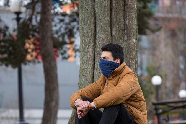 March 28, 2020, Seattle, Washington, U.S: A young man with his face covered by a scarf sits in Seattleâ€⠢s Cal Anderson Park in the Capitol Hill neighborhood on Saturday, March 28, 2020. Under governor Jay Insleeâ€⠢s statewide stay home proclamation, now extended until April 6, people are able to leave their homes only for essential activities including grocery shopping, exercise and caring for a family member, friend or pet. Seattle U.S. - ZUMAg235 20200328_zap_g235_004 Copyright: xPaulxChristianxGordonx