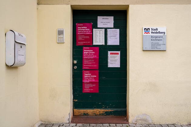 Eindrücke aus Heidelberg (Stadtteil Kirchheim) in Baden-Württemberg in den Tagen der Corona Kontaktsperre, das Bild zeigt die Eingangstür vom Bürgeramt Kirchheim mit Aushängen zur Coronakrise in den Sprachen Deutsch, Englisch und Türkisch, Kontaktverbot, Symbolfoto, Symbolbild, Symbol, 29.03.2020, Heidelberg (Deutschland), News, Coronavirus, Impressionen aus Heidelberg
