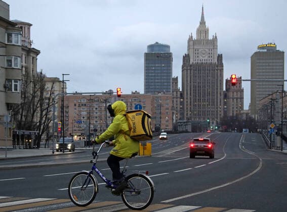 MOSCOW, RUSSIA - APRIL 2, 2020: A courier of the Yandex.Eda food delivery service crossing the Garden Ring on a bicycle. The Moscow authorities imposed home isolation for all Moscow residents, regardless of their age, and restrictions on movement within the city, effective since March 30, 2020, as a measure to contain the spread of the COVID-19 coronavirus infection. Violations of the stay-at-home order carry fines ranging from 1,000 to 40,000 rubles for non-infected people, and up to 1m rubles or imprisonment for up to 3 years for infected people, depending on the severity of consequences. Valery Sharifulin TASS TS0D43BB