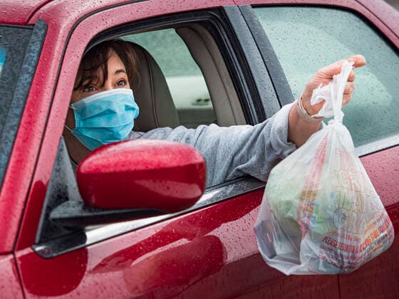 April 11, 2020, Des Moines, Iowa, U.S: A motorist picks a ready to cook pasta meal during a food distribution in Des Moines. Most non-essential businesses in Iowa are closed until 30 April. Because of business closings causes by the Novel Coronavirus (SARS-CoV-2) pandemic, well over 100,000 Iowans filed first time claims for unemployment in the last three weeks, more than applied during the peak of the Great Recession of 2008. Local food banks have seen an unprecedented spike in people seeking nutritional assistance. Midwest Foods, a Des Moines based company and owner of Ginos Fine Italian Foods, gave away 1,000 complete dinners with sauce, noodles, salad, and dressing Saturday morning. People started lining up 3 hours before the food distribution began. The food distribution was done following social distancing guidelines and all of - ZUMAk94_ 20200411_zaf_k94_014 Copyright: xJackxKurtzx