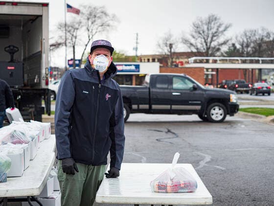 April 11, 2020, Des Moines, Iowa, U.S: JORDON ELWELL, owner and CEO of Midwest Foods, waits for a motorist to pick up a ready to cook pasta meal during a food distribution in Des Moines. Most non-essential businesses in Iowa are closed until 30 April. Because of business closings causes by the Novel Coronavirus (SARS-CoV-2) pandemic, well over 100,000 Iowans filed first time claims for unemployment in the last three weeks, more than applied during the peak of the Great Recession of 2008. Local food banks have seen an unprecedented spike in people seeking nutritional assistance. Midwest Foods, a Des Moines based company and owner of Ginos Fine Italian Foods, gave away 1,000 complete dinners with sauce, noodles, salad, and dressing Saturday morning. People started lining up 3 hours before the food distribution began. The food distribution w - ZUMAk94_ 20200411_zaf_k94_015 Copyright: xJackxKurtzx