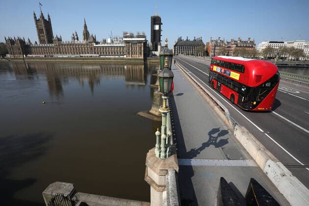 Day Nineteen of Lockdown in London. A red London Bus crosses Westminster Bridge, next to the Houses of Parliament and Big Ben, in London on Easter Saturday. It is the first public holiday of the year, and many people enjoy the long weekend by going out and about or on holiday, but this year the country is on lockdown due to the COVID-19 Coronavirus pandemic. People are not allowed to leave home except for minimal food shopping, medical treatment, exercise - once a day, and essential work. COVID-19 Coronavirus lockdown, London, UK, on April 11, 2020