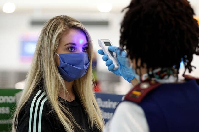 April 14, 2020, Miami, FL, USA: Rosemary Arends, an assistant nurse-flight attendant, checks the temperature of passengers and then helps a group of South African nationals at Miami International Airport boarding a special charter flight by South African Airways on Tuesday, April 14, 2020. Amid the coronavirus pandemic, the flight will repatriate more than 300 South African workers who were supposed to spend these months working at South Florida hotels and resorts. Miami USA - ZUMAm67_ 20200414_zaf_m67_030 Copyright: xPedroxPortalx
