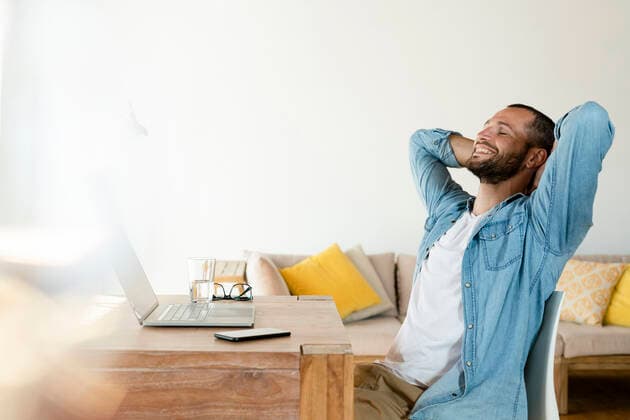 Young man at home working on his laptop in home office having a break model released Symbolfoto property released SBOF02213