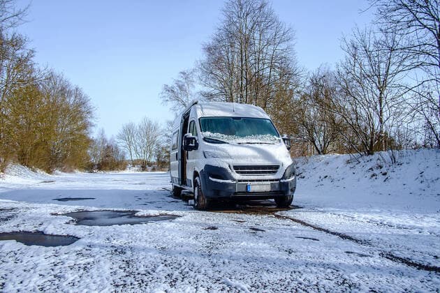 Ein Camperbus steht auf einem Parkplatz im Neuschnee, Donaueschingen, Baden Württemberg, Deutschland. Wohnmobil im Winter