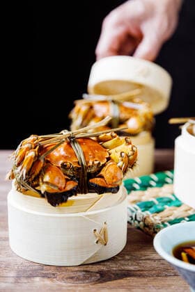 Chinese traditional cuisine in a steamer steamed Yangcheng Lake hairy crabs and seasoned vinegar ginger shreds in a dish. 779640030045929491
