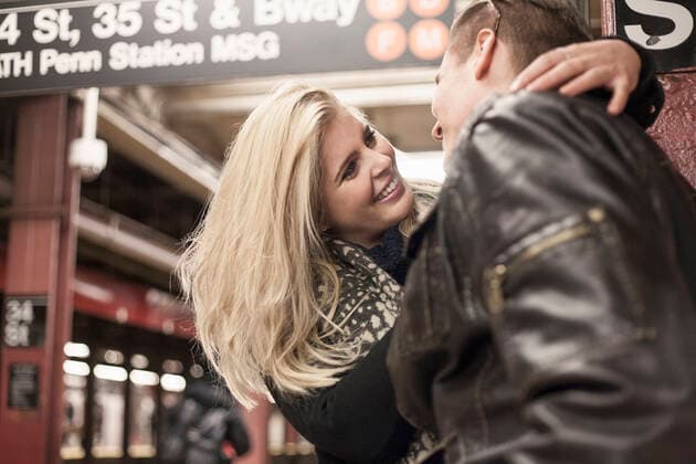 Smiling girlfriend embracing boyfriend while standing at subway station model released Symbolfoto AJOF00868