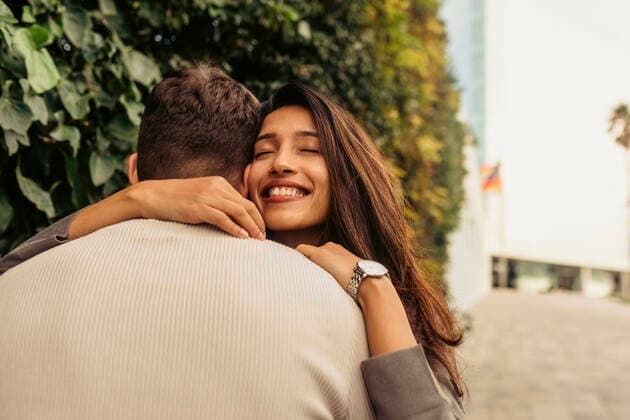 Smiling girlfriend embracing boyfriend at park model released Symbolfoto VABF04207