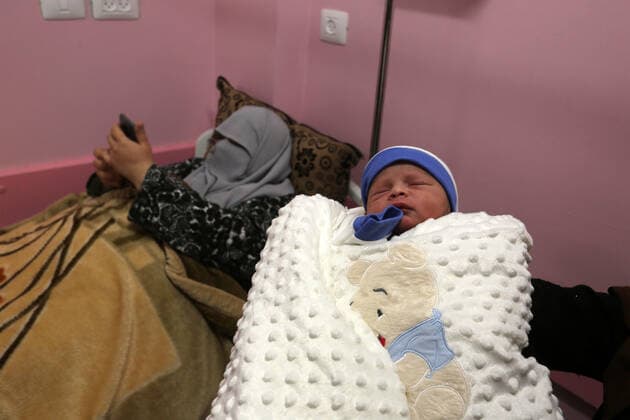 February 18, 2021, khan Younis, Gaza Strip, Palestinian Territory: Relatives of the Palestinian prisoner Muhammad al-Qudra carry the newborn, at Nasser Medical Complex in khan Younis in the southern of Gaza strip on February 18, 2021. Eman al-Qudra gave birth to her newborn in a successful smuggling of sperm to lead to a pregnancy. Since 2004, Palestinian security prisoners, who are denied conjugal visitations by their wives, have tried to smuggle their sperm out of Israeli prisons, so that their wives can be inseminated in fertility clinics in the West Bank and Ghazza, and bear them children khan Younis Palestinian Territory - ZUMAap3_ 20210218_zaf_ap3_169 Copyright: xAshrafxAmrax