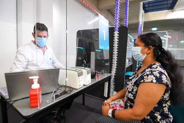 NSW COVID19 VACCINE ROLLOUT, Gayathry Vellangalloor Srinivasan, the first person in NSW to received the Pfizer coronavirus vaccine, registers with medial workers at the Royal Prince Alfred Hospital Vaccination Hub in Sydney, Monday, February 22, 2021. Australia will begin its roll out of the Pfizer coronavirus vaccine on Monday, the country s most complicated logistical exercise to date. ( NO ARCHIVING, EDITORIAL USE ONLY, NO USE IN BOOKS WITHOUT CONSENT SYDNEY NSW AUSTRALIA Copyright: xPETERxRAEx 20210222001522241395