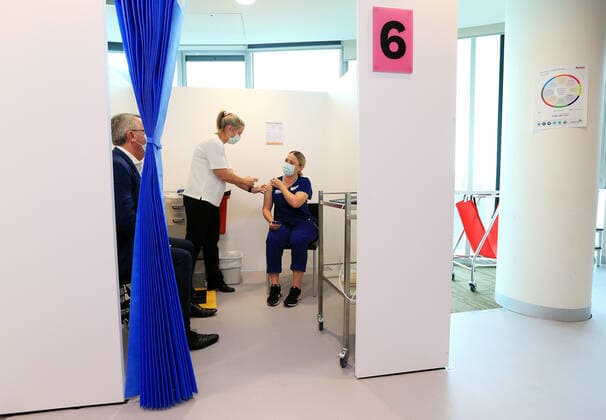 VIC COVID19 VACCINE ROLLOUT, Covid screening nurse Grace Gibney receives one of the first Pfizer coronavirus vaccines from Nurse practitioner Sonja Elia at Austin Health in Melbourne, Monday, February 22, 2021. Australia will begin its roll out of the Pfizer coronavirus vaccine on Monday, the country s most complicated logistical exercise to date. ( NO ARCHIVING, EDITORIAL USE ONLY, NO USE IN BOOKS WITHOUT CONSENT MELBOURNE VIC AUSTRALIA Copyright: xMARKxSTEWARTx 20210222001522293672