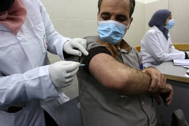 February 23, 2021, Khan Yunis, Gaza Strip, Palestinian Territory: A Palestinian health worker administers a dose of the Russian Sputnik V coronavirus vaccine to a man, at European Hospital, in Khan Yunis, in the southern Gaza Strip on February 23, 2021. Around 20,000 coronavirus vaccine doses from the UAE arrived in Gaza, a delivery reportedly orchestrated by a rival of Palestinian president Mahmud Abbas three months before scheduled Palestinian elections Khan Yunis Palestinian Territory - ZUMAap3_ 20210223_zaf_ap3_047 Copyright: xAshrafxAmrax