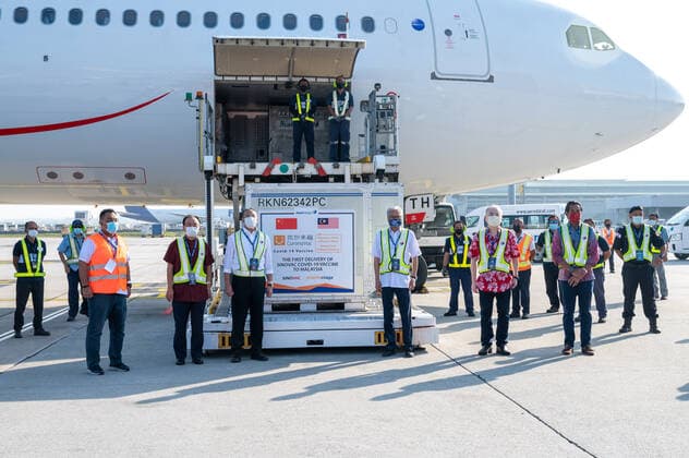 (210227) -- KUALA LUMPUR, Feb. 27, 2021 -- Chinese Ambassador to Malaysia Ouyang Yujing (2nd L, front), Malaysia s Defence Minister Ismail Sabri Yaakob (3rd R, front), Transport Minister Wee Ka Siong (2nd R, front), Foreign Minister Hishammuddin Hussein (3rd L, front), Science, Technology and Innovation Minister Khairy Jamaluddin (1st R, front) pose for photos next to the first batch of COVID-19 vaccines made by the Chinese biopharmaceutical company Sinovac Biotech at the Kuala Lumpur International Airport in Sepang, Malaysia, Feb. 27, 2021. The first batch of COVID-19 vaccines made by the Chinese biopharmaceutical company Sinovac Biotech arrived in Malaysia on Saturday, boosting the country s capability in the fight against the pandemic.