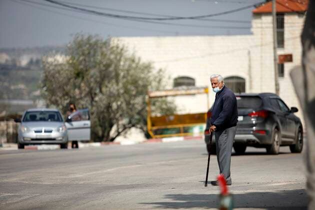 February 28, 2021, Jenin, West Bank, Palestinian Territory: A man walks on an empty street, amid the coronavirus lockdown in the town of Zababdeh, south of Jenin, in the West Bank on February 28, 2021. Prime Minister Mohammad Shtayyeh announced a new set of restrictions in response to a recent surge in coronavirus infections, including of British and South African mutants, in Palestine.A lockdown of all public and private schools for all classes, except for high school students for a period of 12 days, including kindergartens..A lockdown of all universities, educational and vocational institutes and shifting to distance e-learning programs. A maximum of 50 percent of administrative staff are allowed access to universities..Movement between - ZUMAap3_ 20210228_zaf_ap3_044 Copyright: xOdayxDaibesx