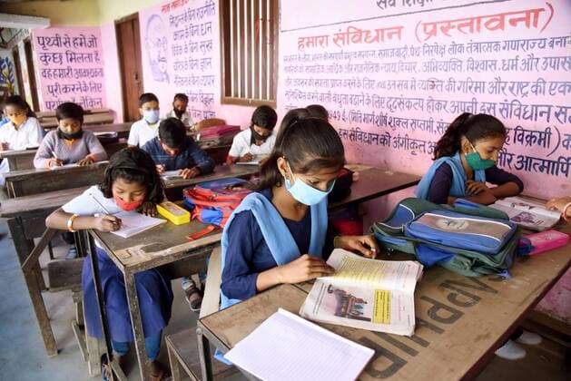 PATNA, INDIA - MARCH 1: Students attending classes at Kanya Madhya Vidyalaya, Adalat Ganj after schools re-opened for the primary section on March 1, 2021 in Patna, India. Nearly a year after the Centre imposed a nationwide lockdown due to the COVID-19 outbreak, several states and UTs have decided to reopen schools and colleges from March 1. As the deadly virus cases are now steadily dropping, the offline classes are going to resume in states such as Bihar, Meghalaya, Jammu and Kashmir, Haryana, among others.(Photo by Santosh Kumar Hindustan Times) Primary Schools Reopen For The First Time Since Lockdown Due To Covid-19