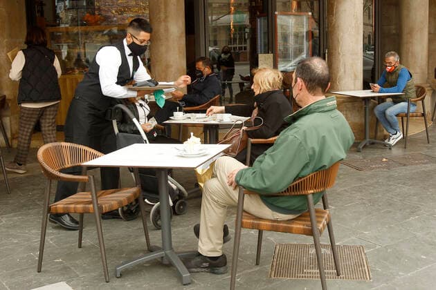 A waiter serves several customers on the terrace of a bar in Palma, Majorca, Balearic Islands, Spain, March 2, 2021. Mallorca receives this Tuesday new measures relating to hospitality and social gatherings. Thus, bars and restaurants on the island will be able to reopen their terraces and social gatherings may be up to six people. 02 MARCH 2021;MALLORCA;FORMENTERA;BALEARIC ISLANDS;HOTEL AND CATERING TRADE Isaac Buj LagenciaEP 03 02 2021 PALMA, MALLORCA, BALEARIC ISLAND PALMA, MALLORCA, BALEARIC ISLAND Spain Copyright: xIsaacxBujx 3588003