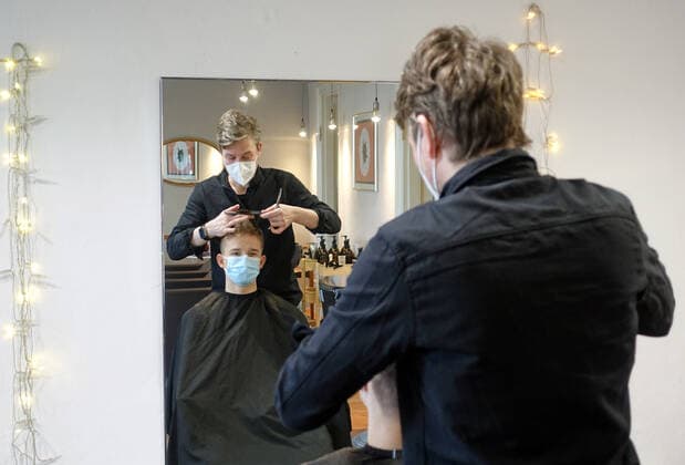 05.03.2021, Berlin, GER - Jugendlicher laesst sich von einem Friseur die Haare schneiden. Am 01.03.2021 durften die Friseure unter Einhaltung der Hygienemassnahmen bundesweit wieder oeffnen, nachdem diese am 16.12.2020 aufgrund des Beginns des harten Lockdowns wegen der Coronapandemie geschlossen werden mussten. (MR=yes, 15-20 Jahre, 40-50 Jahre, Alltag, Arbeit, arbeiten, Berlin, Beruf, Coronaepidemie, Coronapandemie, deutsch, Deutschland, Dienstleistung, Europa, europaeisch, FFP2-Maske, Friseur, Friseurladen, Friseursalon, frisieren, Frisoer, Frisoerladen, Frisoersalon, Frisur, Gesellschaft, Gewerbe, Haare, Haare schneiden, Haarpflege, Haarschnitt, Handwerk, Hygienekonzept, Hygienemassnahmen, innen, Innenaufnahme, Jugendlicher, Kaukasier,