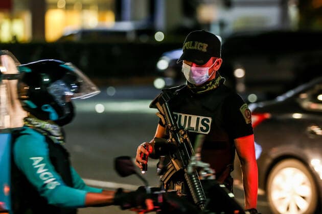 Coronavirus auf den Philippinen, Polizei überwacht Ausgangssperre (210315) -- MANILA, March 15, 2021 -- A policeman checks a motorist at a checkpoint during the implementation of strict quarantine measures in Manila, the Philippines on March 15, 2021. Metro Manila, home to about 13 million people, started imposing strict quarantine measures again on Monday to contain a recent surge of coronavirus infections. The Philippines Department of Health (DOH) reported on Monday that 5,404 new coronavirus disease (COVID-19) infections, the highest daily tally in seven months, bringing the total number of confirmed cases in the country to 626,893. ) PHILIPPINES-MANILA-COVID-19-QUARANTINE MEASURES RouellexUmali