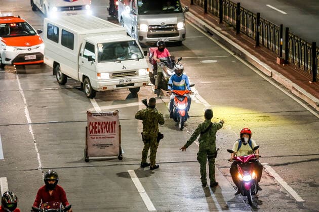 Coronavirus auf den Philippinen, Polizei überwacht Ausgangssperre (210315) -- MANILA, March 15, 2021 -- Policemen work at a checkpoint for passing motorists during the implementation of strict quarantine measures in Manila, the Philippines on March 15, 2021. Metro Manila, home to about 13 million people, started imposing strict quarantine measures again on Monday to contain a recent surge of coronavirus infections. The Philippines Department of Health (DOH) reported on Monday that 5,404 new coronavirus disease (COVID-19) infections, the highest daily tally in seven months, bringing the total number of confirmed cases in the country to 626,893. ) PHILIPPINES-MANILA-COVID-19-QUARANTINE MEASURES RouellexUmali