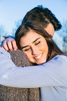 Smiling girlfriend embracing boyfriend during sunset model released Symbolfoto ABZF03506