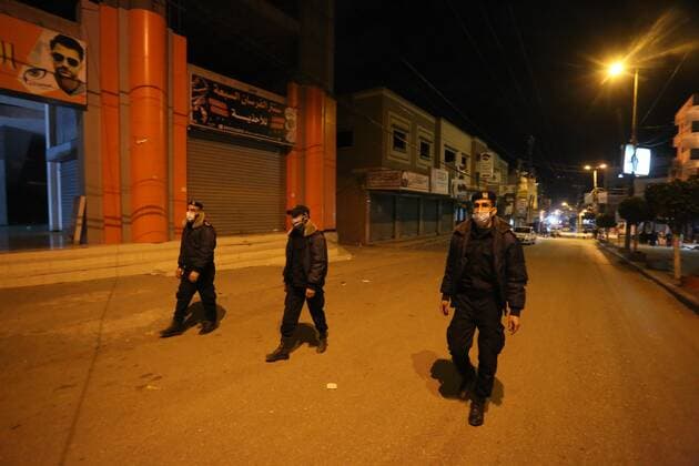 March 27, 2021, Deir Al-Balah, Gaza Strip, Palestinian Territory: Palestinian policemen wear face masks, guard a barrier blocking a road, in Deir Al-Balah in the center of the Gaza Strip, on March 27, 2021, after the Ministry of Interior in Gaza City announced the full lockdown on Saturday all over the Gaza Strip at night-time from 9:00 PM, after the increase in cases infected with Coronavirus Deir Al-Balah Palestinian Territory - ZUMAap3_ 20210327_zaf_ap3_207 Copyright: xAshrafxAmrax
