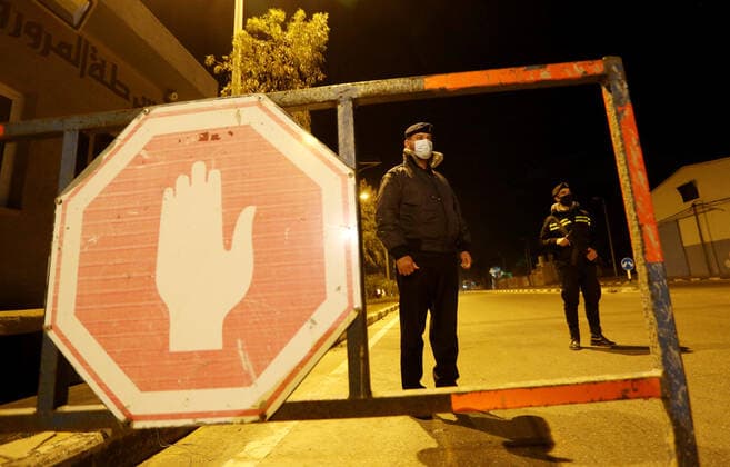March 27, 2021, Deir Al-Balah, Gaza Strip, Palestinian Territory: Palestinian policemen wear face masks, guard a barrier blocking a road, in Deir Al-Balah in the center of the Gaza Strip, on March 27, 2021, after the Ministry of Interior in Gaza City announced the full lockdown on Saturday all over the Gaza Strip at night-time from 9:00 PM, after the increase in cases infected with Coronavirus Deir Al-Balah Palestinian Territory - ZUMAap3_ 20210327_zaf_ap3_222 Copyright: xAshrafxAmrax