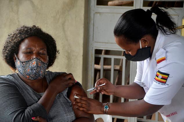 (210331) -- KAMPALA, March 31, 2021 -- A teacher receives a dose of COVID-19 vaccine at a health center in Kampala, capital of Uganda, March 31, 2021. Uganda launched the first phase of COVID-19 vaccination campaign on March 10, targeting high risk groups in the east African country. The ministry of health targets to vaccinate more than 21.9 million people who face the highest risk of the infection, which include health workers, teachers, security personnel, elderly and those with underlying medical conditions. (Photo by Xinhua) UGANDA-KAMPALA-TEACHERS-VACCINATION NicholasxKajoba