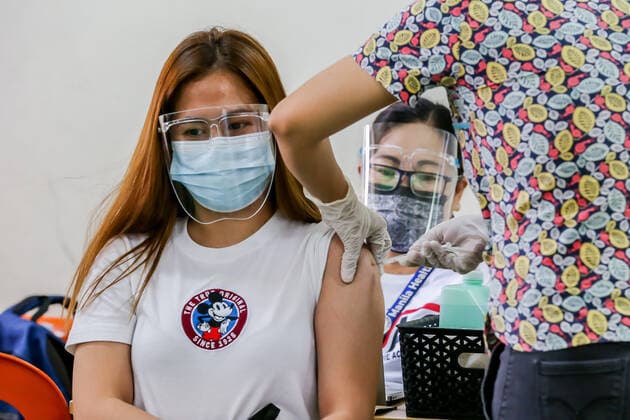 (210404) -- MANILA, April 4, 2021 -- A resident is inoculated with a dose of CoronaVac COVID-19 vaccine, made by Sinovac Biotech, at a vaccination site in Manila, the Philippines on April 4, 2021. The Philippines Department of Health (DOH) reported 11,028 new COVID-19 infections on Sunday, bringing the total number of confirmed cases in the Southeast Asian country to 795,051. The death toll climbed to 13,425 after two more patients died from the viral disease, the DOH said. ) PHILIPPINES-MANILA-COVID-19-VACCINATION RouellexUmali