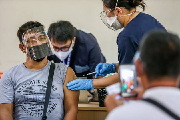 (210404) -- MANILA, April 4, 2021 -- A resident is inoculated with a dose of CoronaVac COVID-19 vaccine, made by Sinovac Biotech, at a vaccination site in Manila, the Philippines on April 4, 2021. The Philippines Department of Health (DOH) reported 11,028 new COVID-19 infections on Sunday, bringing the total number of confirmed cases in the Southeast Asian country to 795,051. The death toll climbed to 13,425 after two more patients died from the viral disease, the DOH said. ) PHILIPPINES-MANILA-COVID-19-VACCINATION RouellexUmali