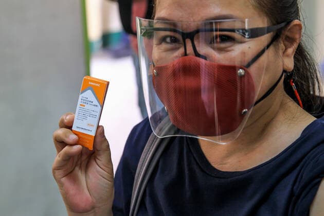 (210404) -- MANILA, April 4, 2021 -- A resident shows a box of CoronaVac COVID-19 vaccine, made by Sinovac Biotech, after being inoculated at a vaccination site in Manila, the Philippines on April 4, 2021. The Philippines Department of Health (DOH) reported 11,028 new COVID-19 infections on Sunday, bringing the total number of confirmed cases in the Southeast Asian country to 795,051. The death toll climbed to 13,425 after two more patients died from the viral disease, the DOH said. ) PHILIPPINES-MANILA-COVID-19-VACCINATION RouellexUmali