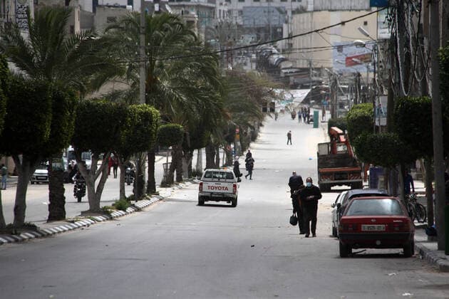 April 10, 2021, Gaza city, Gaza Strip, Palestinian Territory: Paestinians walk at a deserted street is pictured during a lockdown following the outbreak of the coronavirus disease (COVID-19), in Gaza city, on April 10, 2021. New coronavirus cases were down today in the West Bank and Gaza Strip as the death toll remained high. Ministery of Health reported on the disease in Palestine that 438 new cases, 16 deaths, and 812 recoveries were recorded in the West Bank over the last 24 hours, while 1064 new cases, 10 deaths, and 600 recoveries were recorded in the Gaza Strip Gaza city Palestinian Territory - ZUMAap3_ 20210410_zaf_ap3_006 Copyright: xMahmoudxAjjourx