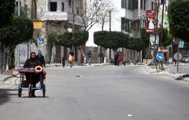 April 10, 2021, Gaza city, Gaza Strip, Palestinian Territory: Paestinians walk at a deserted street is pictured during a lockdown following the outbreak of the coronavirus disease (COVID-19), in Gaza city, on April 10, 2021. New coronavirus cases were down today in the West Bank and Gaza Strip as the death toll remained high. Ministery of Health reported on the disease in Palestine that 438 new cases, 16 deaths, and 812 recoveries were recorded in the West Bank over the last 24 hours, while 1064 new cases, 10 deaths, and 600 recoveries were recorded in the Gaza Strip Gaza city Palestinian Territory - ZUMAap3_ 20210410_zaf_ap3_016 Copyright: xMahmoudxAjjourx