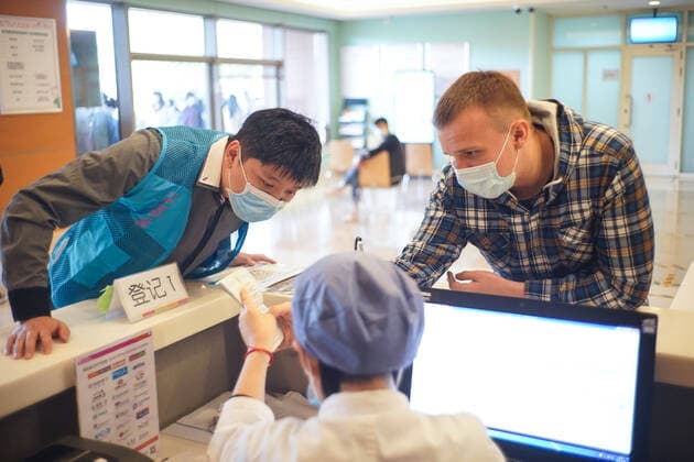 Coronavirus in China, Impfstart für Ausländer in Peking (210415) -- BEIJING, April 15, 2021 -- Qi Yan (L), a voluntary interpreter, helps a medical worker communicate with a foreign national at a vaccination site in Beijing, capital of China, April 15, 2021. Beijing has recently started COVID-19 vaccination for foreign nationals in the city. Foreign nationals aged 18 and above may, following the principle of voluntary participation, giving informed consent and assuming personal responsibility for risk, take the COVID-19 vaccine. ) CHINA-BEIJING-FOREIGNERS-COVID-19-VACCINATION (CN) PengxZiyang