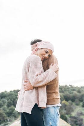 Smiling girlfriend embracing boyfriend model released Symbolfoto DAMF00755