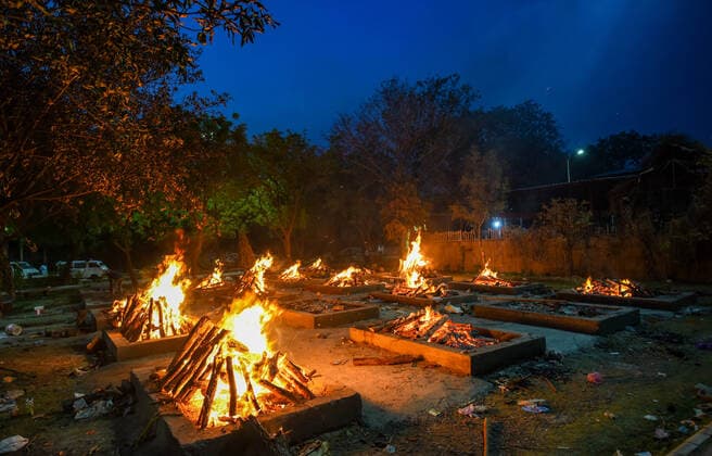 NEW DELHI, INDIA - APRIL 28: Funeral pyres of Covid-19 victims at Sarai Kale Khan crematorium, on April 28, 2021 in New Delhi, India. India, in the last 24 hours, recorded 3,60,960 fresh Covid-19 cases and 3,293 deaths, which is the highest in the country so far. With today?s numbers, the total number of coronavirus cases rose to 1,79,97,267 and the number of fatalities reached 2,01,187. At present, there are 29,78,709 active cases in India and as many as 1,48,17,371 people have recovered. (Photo by Amal KS Hindustan Times) Covid Death Toll Continues To Rise In India