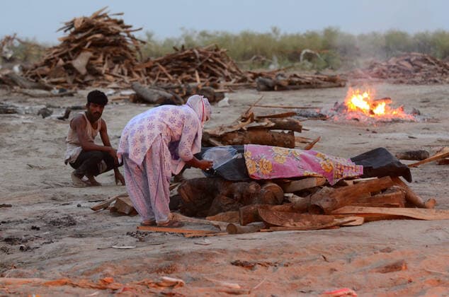 May 6, 2021, Prayagraj, Uttar Pradesh, India: Prayagraj: Relatives perform last rites of a relative who was thought to have died of Covid-19 to a funeral pyre at a mass crematorium site on the banks of the Ganga river on May 06, 2021 in Allahabad, India. India recorded more than 360,000 coronavirus cases in a day for the 12th day in a row on Monday as the total number of those infected according to Health Ministry data neared 20 million. The real figure could be up to ten times higher, many health experts say, due to a lack of widespread testing or reporting, and only patients who succumbed in hospitals being counted. A new wave of the pandemic has totally overwhelmed the country s healthcare services and has caused crematoriums to operate - ZUMAv115 20210506_zap_v115_032 Copyright: xPrabhatxKumarxVermax