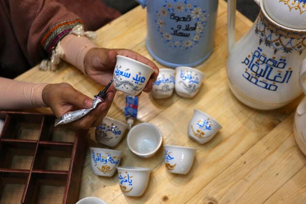 May 8, 2021, Maghazi, Gaza Strip, Palestinian Territory: Palestinian artist, Abeer Al-Tallaa, 23, paints on the pots and cups of coffee the congratulatory phrases for Eid Al Fitr, at Maghazi refugee camp in the center of the Gaza Strip, on May 8, 2021. People flock markets and shopping malls as they shop for food and new clothings in preparation for Eid al Fitr holiday that marks the end of Ramadan, the holiest month in Islamic calendar Maghazi Palestinian Territory - ZUMAap3_ 20210508_zaf_ap3_033 Copyright: xAshrafxAmrax